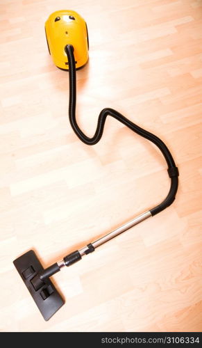 Vacuum cleaner on the polished wooden floor