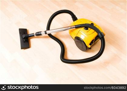 Vacuum cleaner on the polished wooden floor