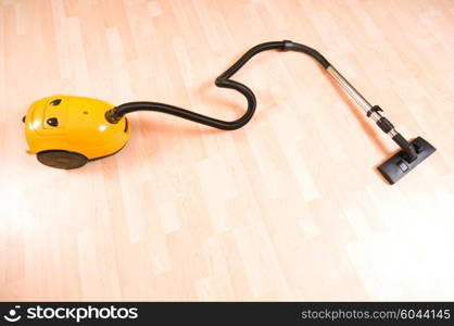 Vacuum cleaner on the polished wooden floor