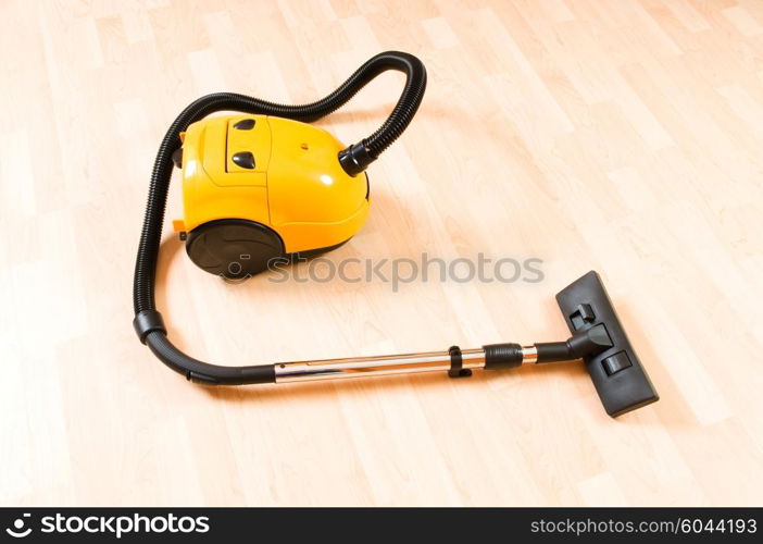 Vacuum cleaner on the polished wooden floor