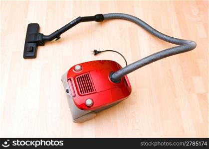 Vacuum cleaner on the wooden floor