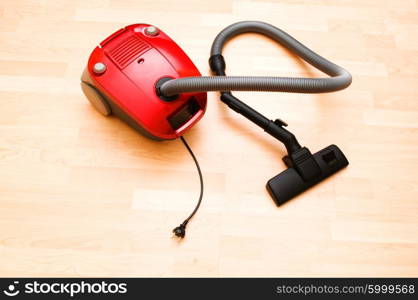 Vacuum cleaner on the wooden floor