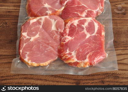 Vacuum packed meat displayed on a wooden background