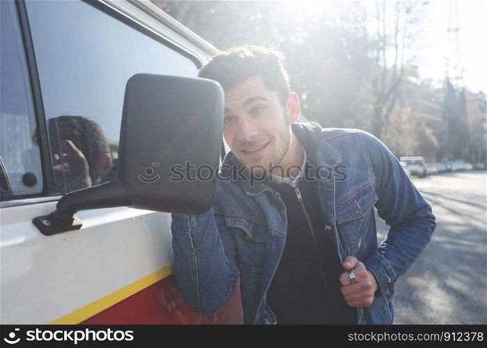 Vain man checking his looks in the mirror of his van