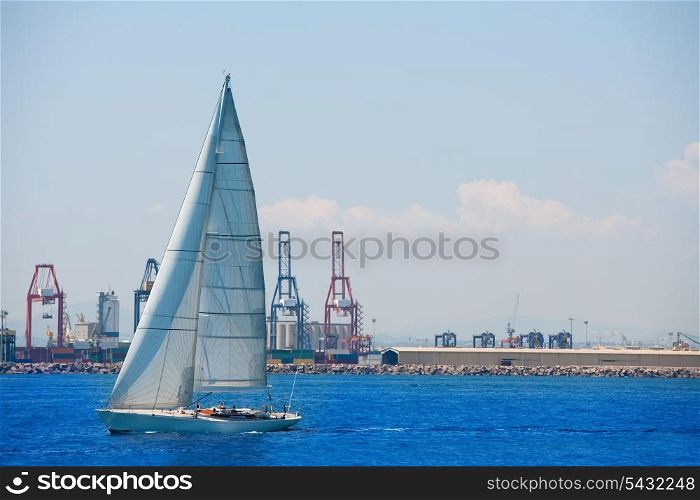Valencia city port with sailboat and cranes in background at spain