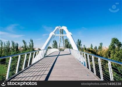Valencia, Spain - White suspension bridge in Valencia Bioparc under blue sky in autumn