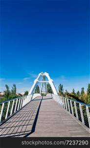 Valencia, Spain - White suspension bridge in Valencia Bioparc under blue sky in autumn