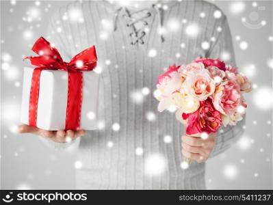 valentine&#39;s day, christmas, x-mas, winter, happiness concept - man holding bouquet of flowers and gift box