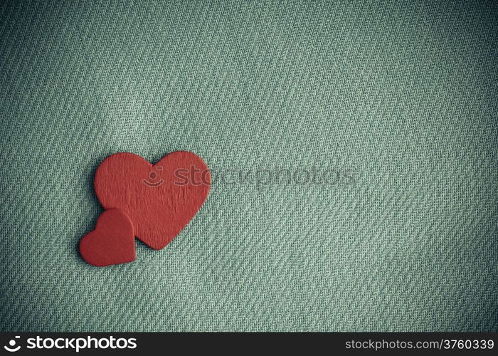 Valentine&#39;s day or wedding. Red wooden decorative two hearts on abstract gray cloth textile background with copy space