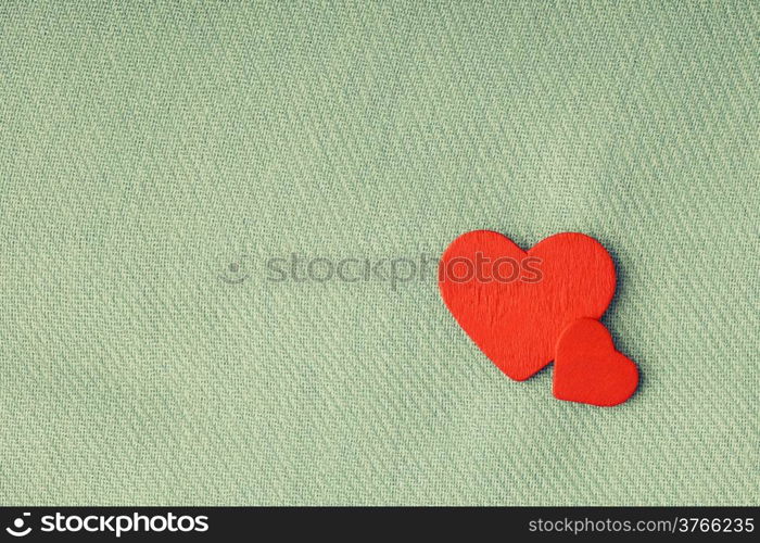 Valentine&#39;s day or wedding. Red wooden decorative two hearts on abstract gray cloth textile background with copy space