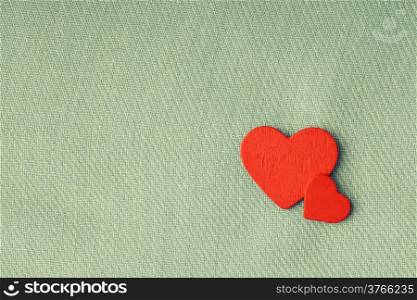 Valentine&#39;s day or wedding. Red wooden decorative two hearts on abstract gray cloth textile background with copy space