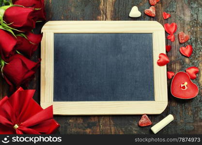 Valentine composition with chalkboard and flowers on wooden background