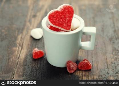 Valentine composition with hearts in a blue cup on wooden background