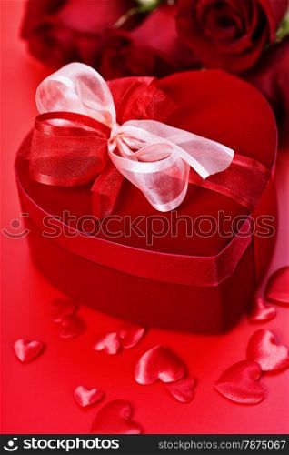 Valentine composition with roses and gift box on red background