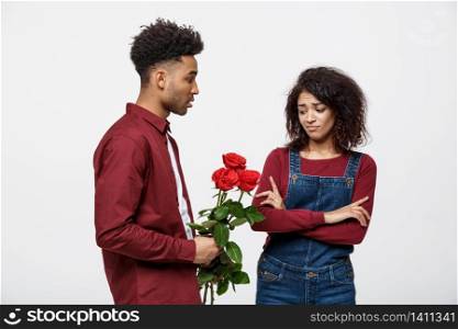 Valentine concept - young african american woman upset and ignore rose from her boyfriend. Valentine concept - young african american woman upset and ignore rose from her boyfriend.