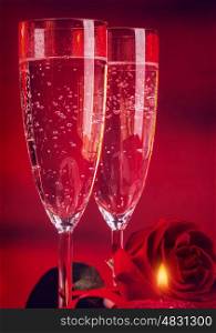 Valentine day dinner, two elegant glass of champagne decorated with red rose and candle, romantic still life, love and passion concept