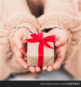 Valentine Day. Female beauty hands holding small gift package box present wrapped paper with ribbon isolated on white background, Christmas, New year, Birthday holiday background concept