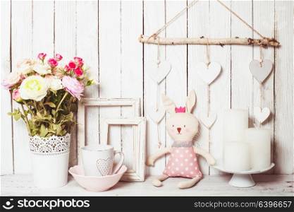 Valentine day gifts such as rose in white vase, white mug, scented candles, empty frames and toy bunny. Presents for Valentine