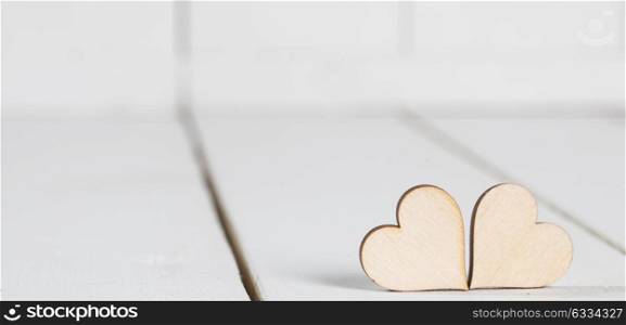 Valentine day hearts. Two wooden Valentine day hearts on white wooden background