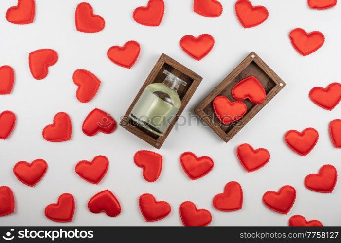 Valentine day white wood background with gift box with home aroma fragrance diffuser with red hearts. Valentines day gift or love concept. Valentine day white wood background