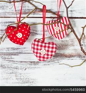 Valentine decorations: textile red hearts on the branch