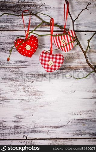 Valentine decorations: textile red hearts on the branch