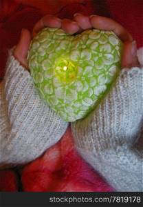 Valentine heart and heart shape candle in woman hands