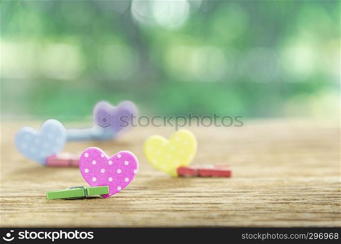 Valentine, love and wedding background concept. Colorful hearts on wood table with blurred nature background. Sweet holiday backdrop. Picture for add text message. Backdrop for design art work.