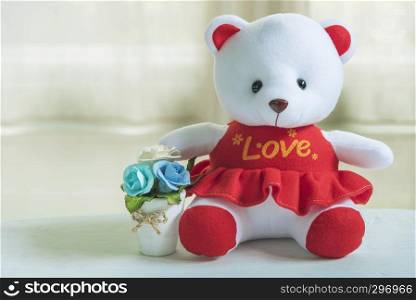Valentine, love and wedding background concept. Cute lovely bear with ?Love? shirt and flower pot with white background. Picture for add text message. Backdrop for design art work.