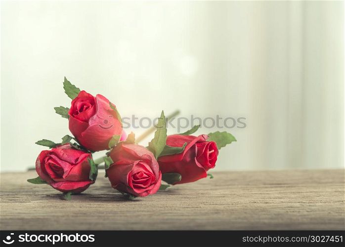 Valentine, love and wedding background concept. Red roses on woo. Valentine, love and wedding background concept. Red roses on wooden table with window light background. Picture for add text message. Backdrop for design art work.