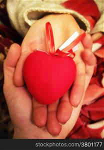 Valentine red heart in woman and man hands