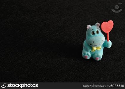 Valentine&rsquo;s day. A hippo figurine holding a red heart