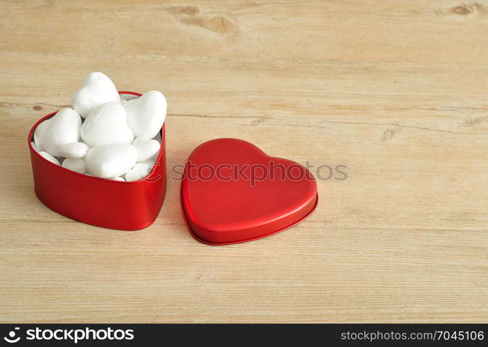 Valentine&rsquo;s Day. A red heart shape tin filled with with polystyrene hearts