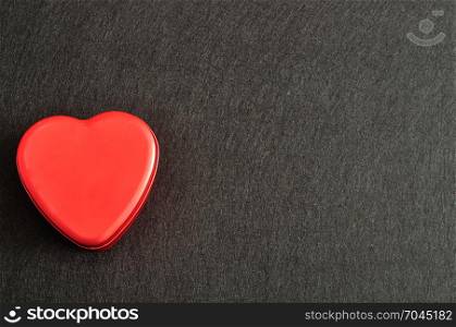 Valentine&rsquo;s Day. A red heart shape tin isolated on a black background