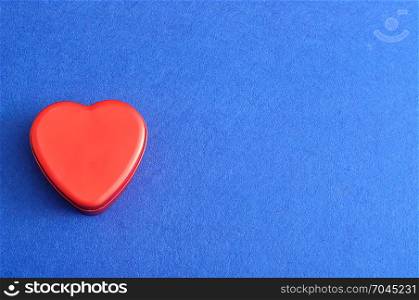 Valentine&rsquo;s Day. A red heart shape tin isolated on a blue background