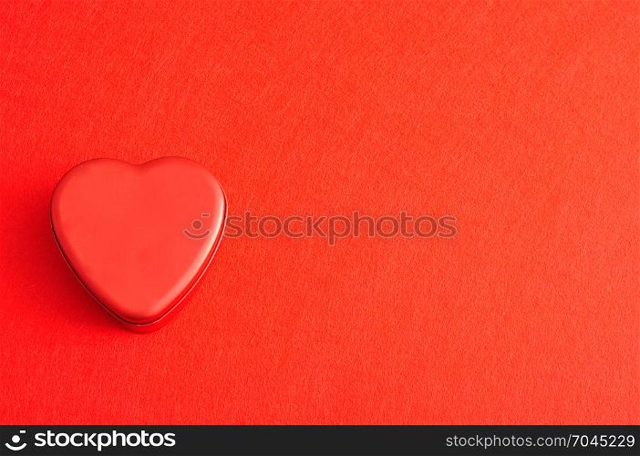 Valentine&rsquo;s Day. A red heart shape tin isolated on a red background