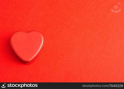 Valentine&rsquo;s Day. A red heart shape tin isolated on a red background