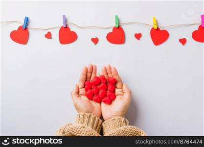 Valentine&rsquo;s day and birthday. Woman hands holding red heart present decorated surprise on white background, Female&rsquo;s hand hold gift heart on hands, Top view flat lay composition
