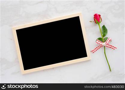 Valentine's day background, template, Red rose and blank chalkboard on white marble background with copy space for text, flat lay