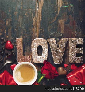 Valentine's day background with cup of coffee, chocolate, gifts, roses and love wooden letters.Valentines day concept. Top view. Copy space.