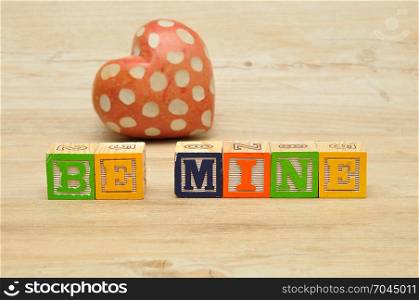 Valentine&rsquo;s Day. Be Mine spelled with colorful alphabet blocks and a red heart
