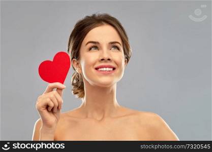 valentine&rsquo;s day, beauty and people concept - happy smiling beautiful young woman holding red heart over grey background. beautiful smiling woman holding red heart