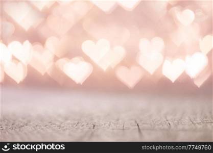 Valentine&rsquo;s Day bokeh pink lights hearts over wooden table background woth copy space for product. Valentine&rsquo;s Day bokeh hearts background