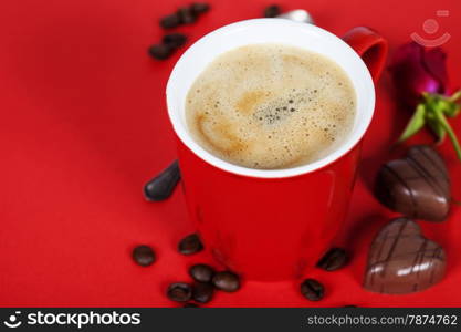 Valentine&rsquo;s day composition with coffee cup and chocolate on red background