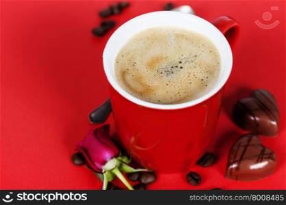 Valentine&rsquo;s day composition with coffee cup and chocolate on red background