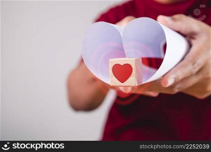 Valentine&rsquo;s day concept. Person holds heart shape paper and wood box with visual effect. Give a love to you.