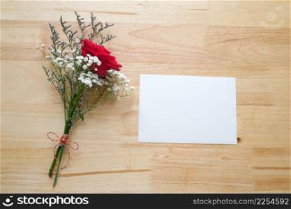 Valentine&rsquo;s day concept, Red roses flower bouquet and blank white note paper on wood background with copy space , Banner for mock up, template, top view, flate lay
