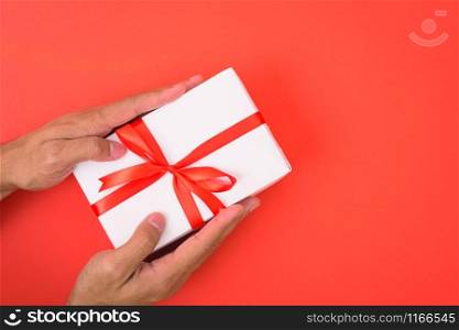 Valentine&rsquo;s Day Concept, Top view Flat lay, Hand holding gift box on red background with copy space for your text