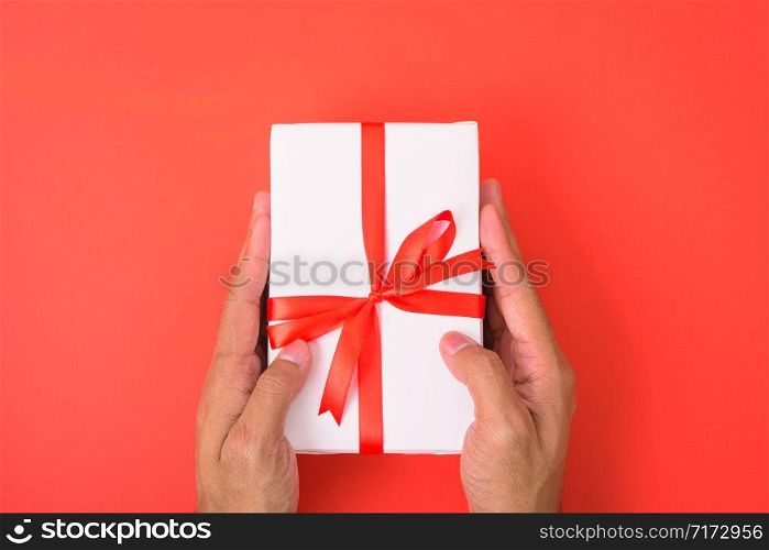 Valentine&rsquo;s Day Concept, Top view Flat lay, Hand holding gift box on red background with copy space for your text