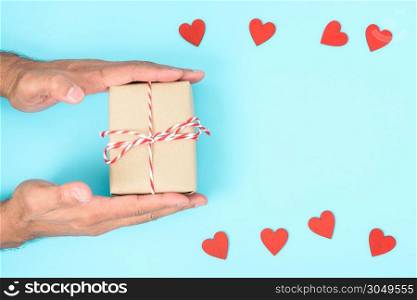 Valentine&rsquo;s Day Concept, Top view Flat lay, have red heart and hand holding gift box on blue background with copy space for your text